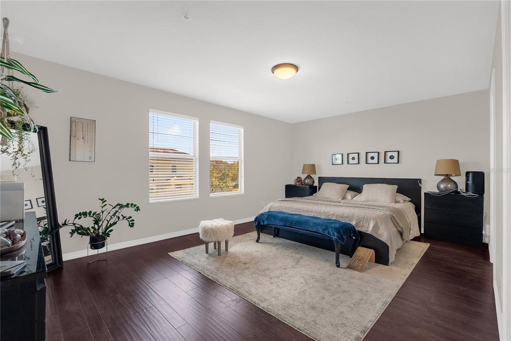 2096 Water Tupelo Way Ocoee, FL 34761 - Photo 19 of 32 a bedroom with a bed and wooden floor