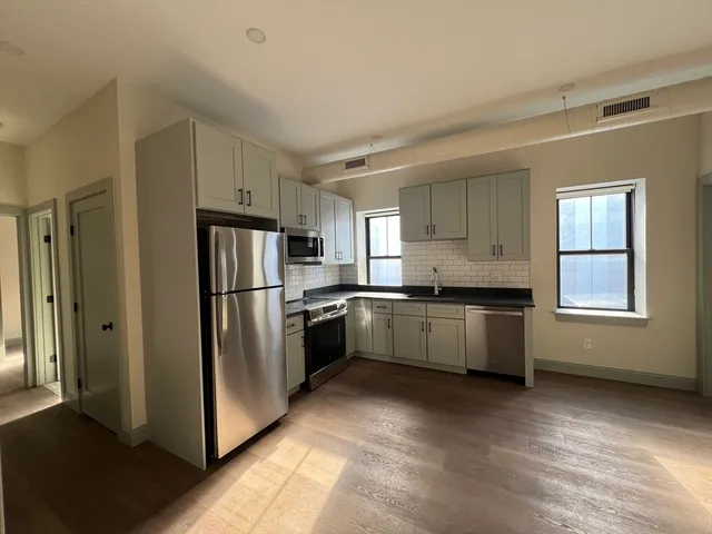 a large kitchen with cabinets and stainless steel appliances