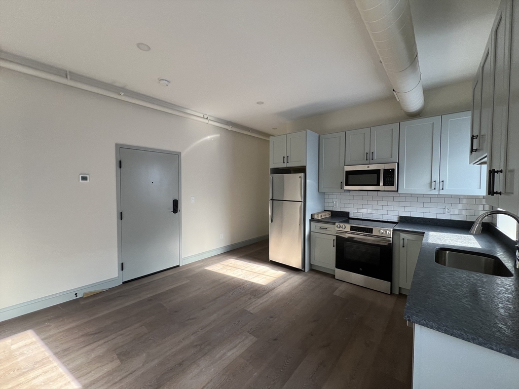 160 Seabury Street, Unit 5 Fall River, MA 02720 - Photo 3 of 10 a kitchen with stainless steel appliances granite countertop a refrigerator a stove top oven a sink and dishwasher