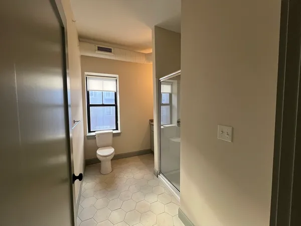 a bathroom with a toilet and a shower