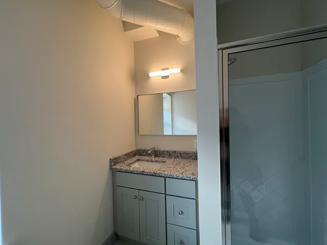 a bathroom with a granite countertop sink and a mirror