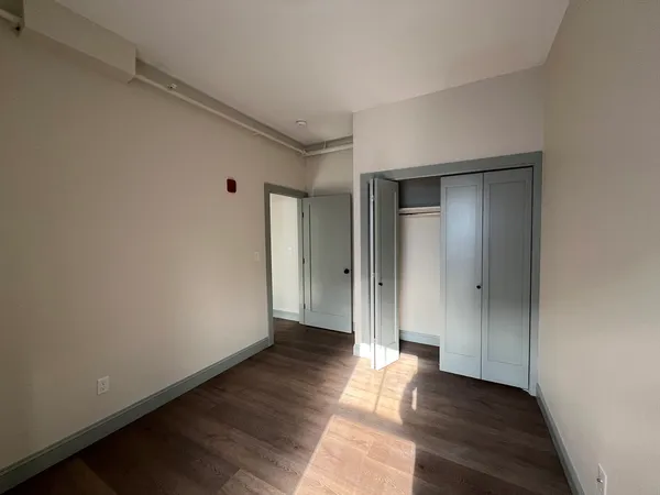 a view of an empty room with wooden floor
