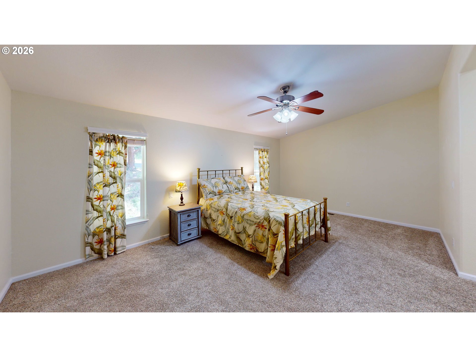 94355 11th Street Gold Beach, OR 97444 - Photo 8 of 41 a bedroom with a bed and a ceiling fan