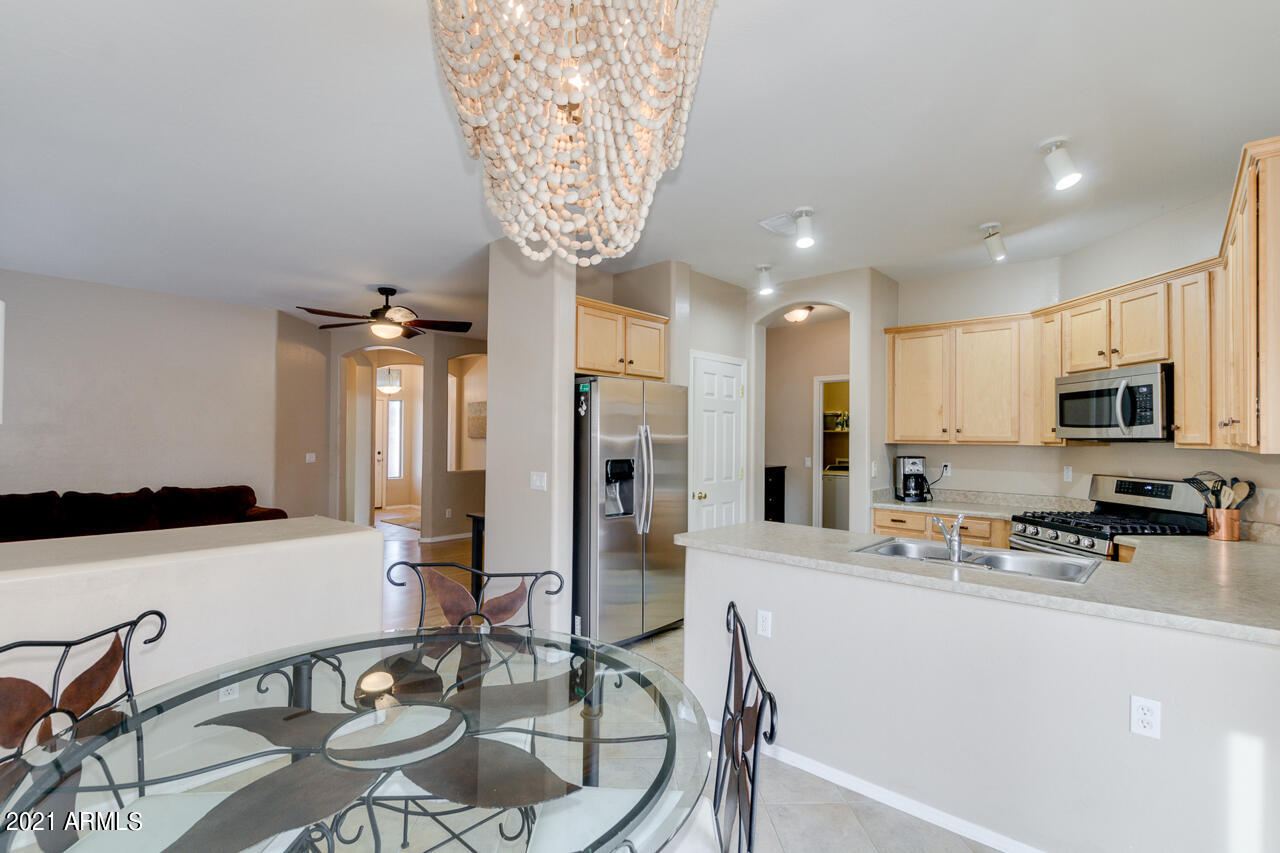 44 South Greenfield Road, Unit 48 Mesa, AZ 85206 - Photo 12 of 32 a kitchen with stainless steel appliances granite countertop a sink a stove and a refrigerator