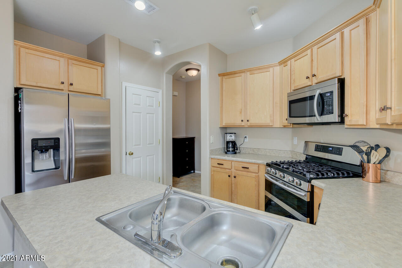 44 South Greenfield Road, Unit 48 Mesa, AZ 85206 - Photo 13 of 32 a kitchen with stainless steel appliances granite countertop a stove a sink and a refrigerator