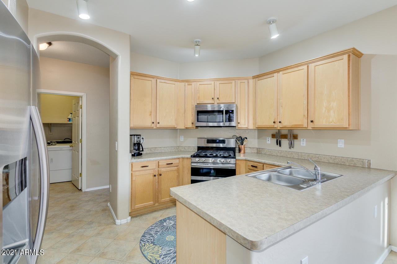 44 South Greenfield Road, Unit 48 Mesa, AZ 85206 - Photo 14 of 32 a kitchen with stainless steel appliances granite countertop a sink stove and refrigerator