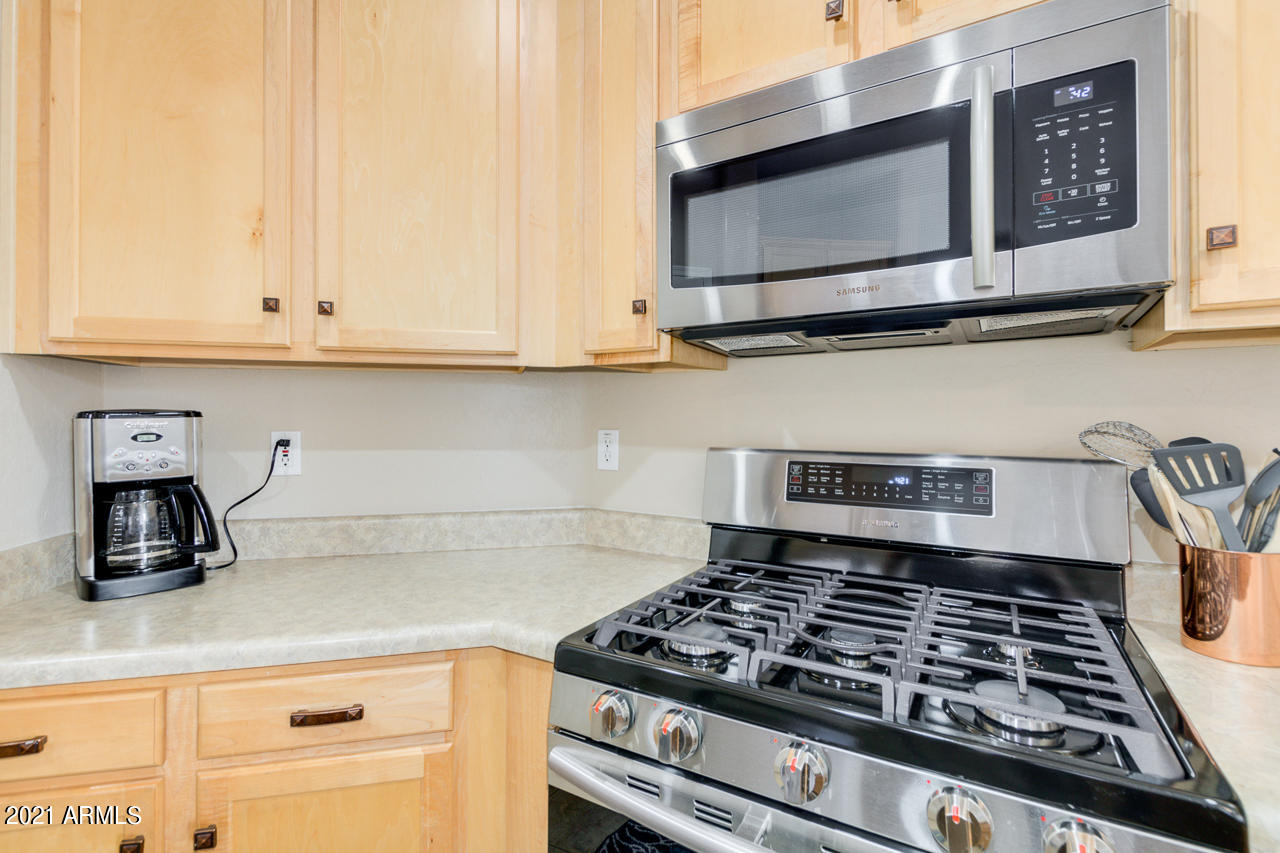 44 South Greenfield Road, Unit 48 Mesa, AZ 85206 - Photo 16 of 32 a kitchen with granite countertop a stove and a microwave