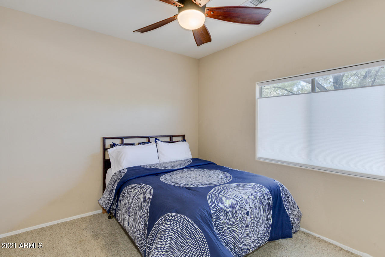 44 South Greenfield Road, Unit 48 Mesa, AZ 85206 - Photo 24 of 32 a bedroom with a bed and a chandelier