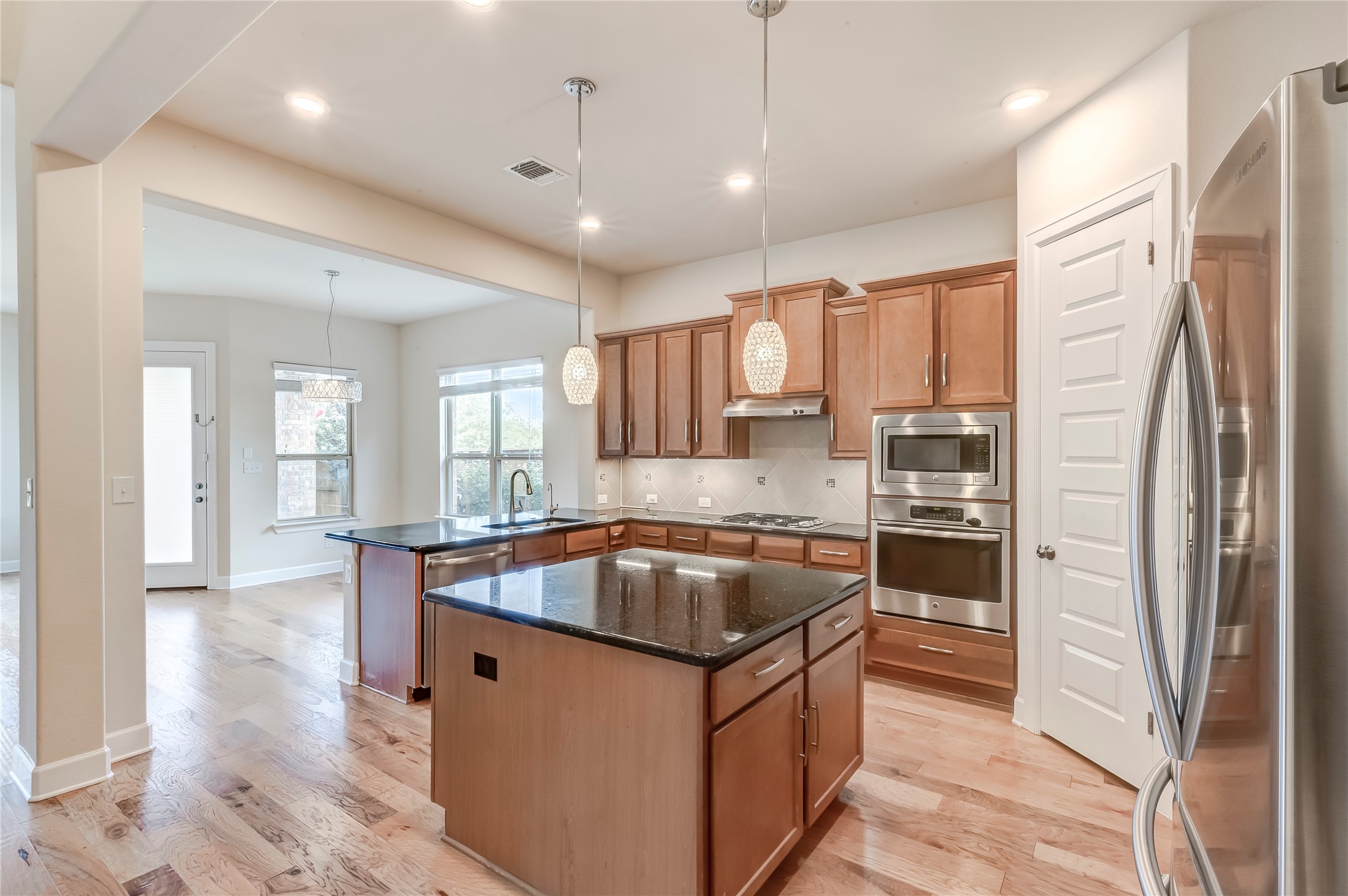 345 Fort Cobb Way Georgetown, TX 78628 - Photo 9 of 38 Gleaming hardwood floors and a spacious central island define this modern culinary workspace.