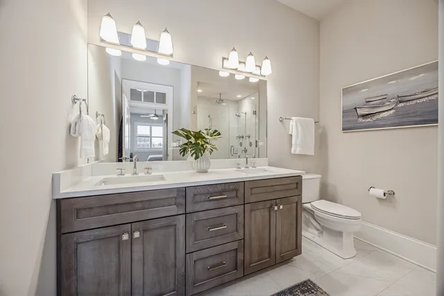 a bathroom with a granite countertop sink a toilet and a mirror
