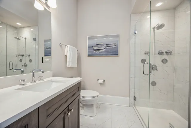 a bathroom with a sink a toilet and shower