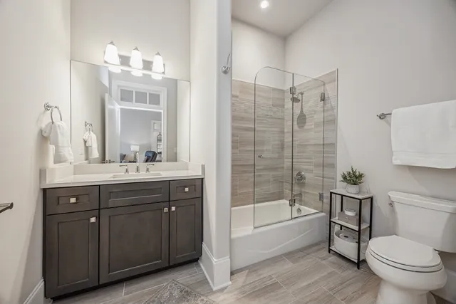 a bathroom with a granite countertop toilet a sink and a bathtub