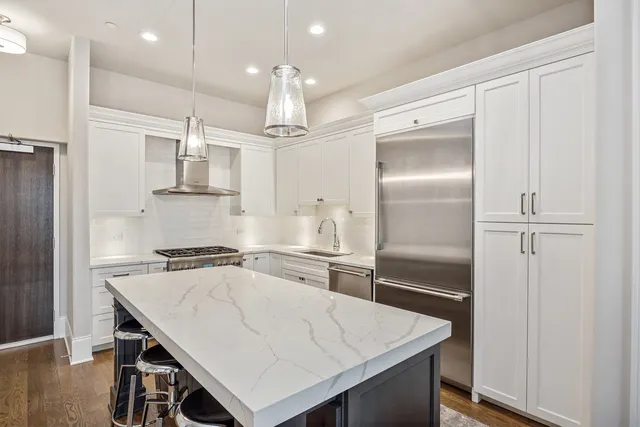 a kitchen with kitchen island a sink stove and refrigerator