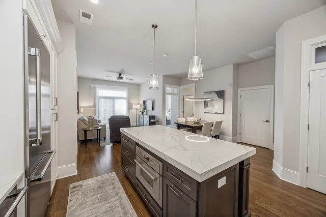 a kitchen that has a lot of cabinets a sink and wooden floor