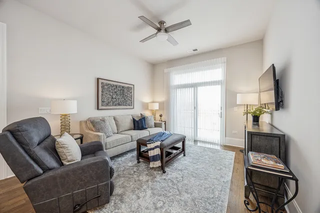 a living room with furniture a flat screen tv and a window
