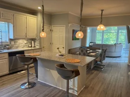 a kitchen with a table chairs and wooden floor