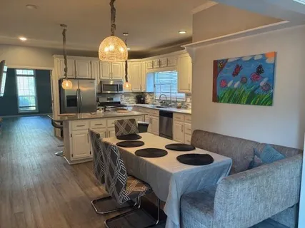a kitchen with kitchen island stainless steel appliances a dining table and chairs