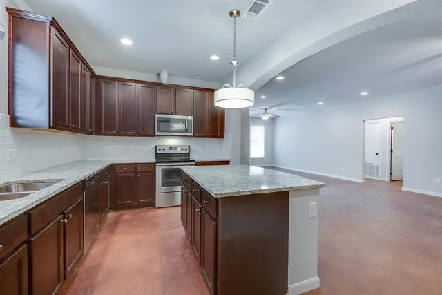 a kitchen with a stove sink and cabinets