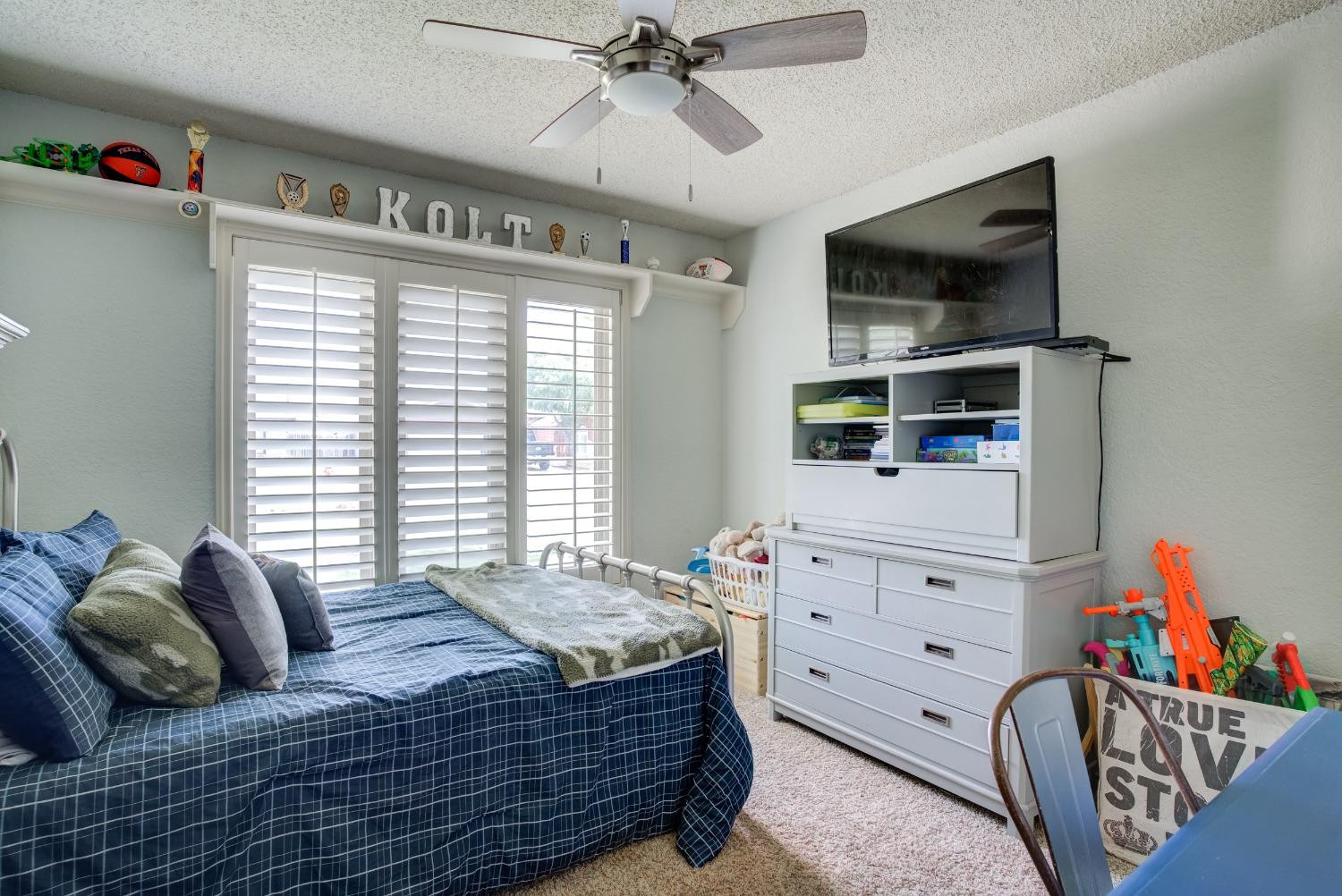 1428 5th Street Shallowater, TX 79363 - Photo 17 of 30 a bedroom with a bed and a flat tv screen on dresser