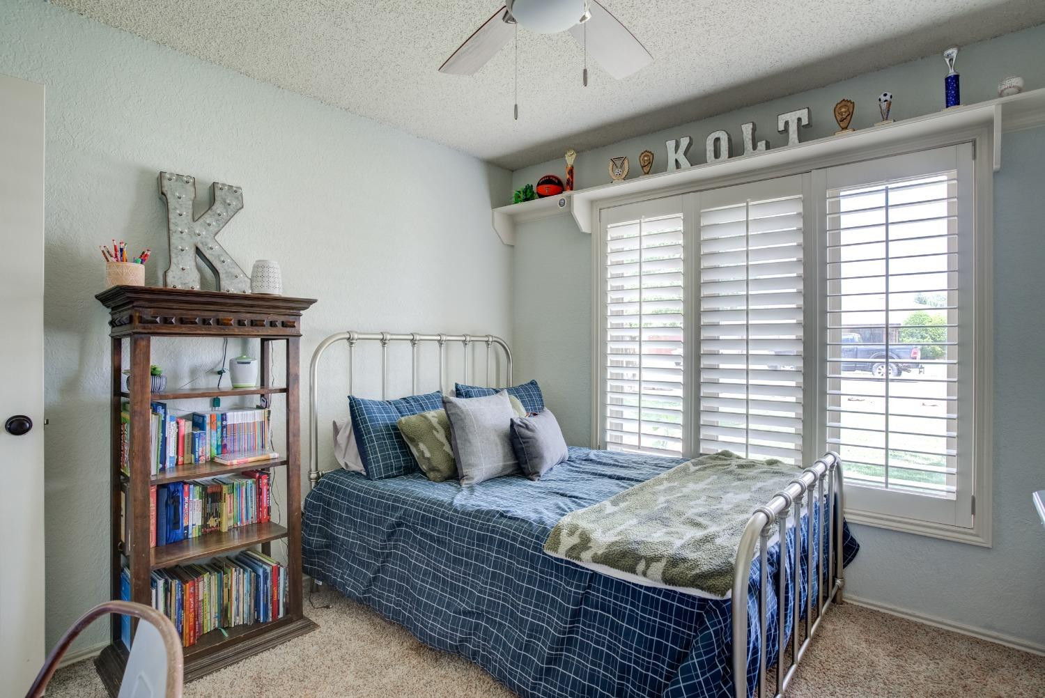 1428 5th Street Shallowater, TX 79363 - Photo 18 of 30 a bedroom with a bed and book shelf