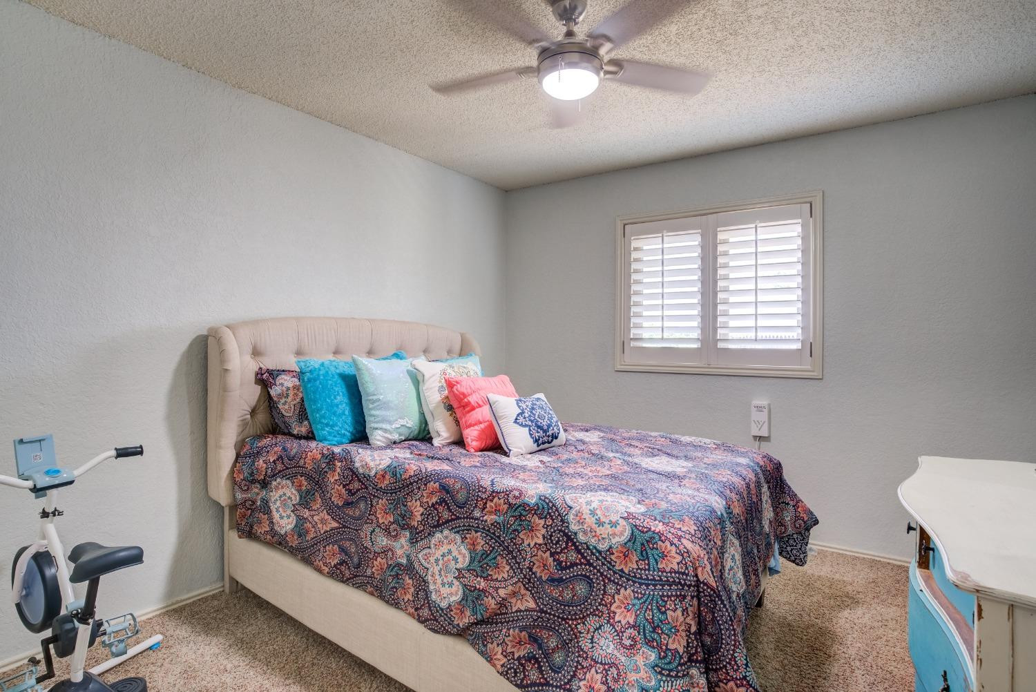 1428 5th Street Shallowater, TX 79363 - Photo 21 of 30 a bedroom with a large bed and a chandelier