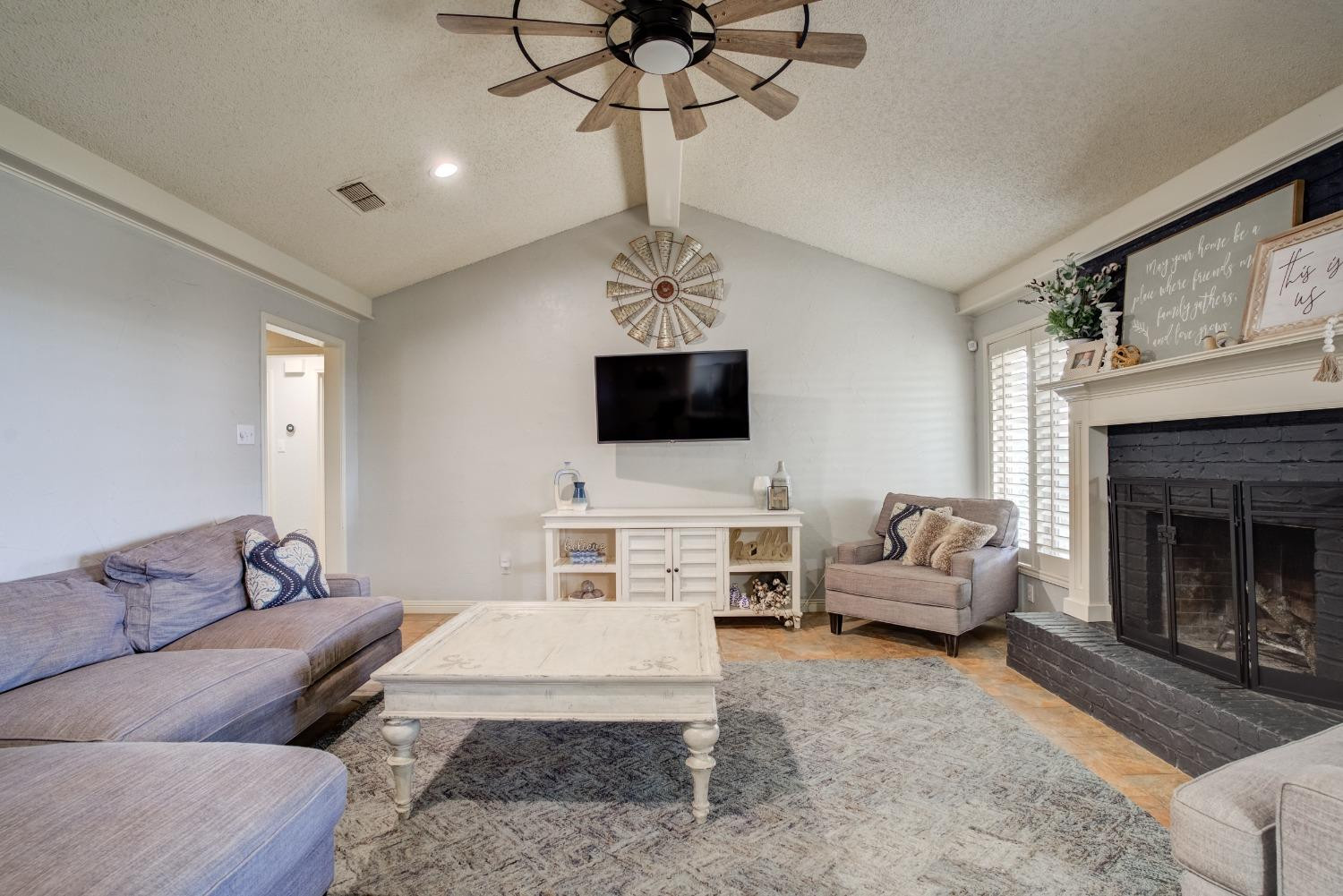 1428 5th Street Shallowater, TX 79363 - Photo 5 of 30 a living room with furniture a fireplace and a flat screen tv