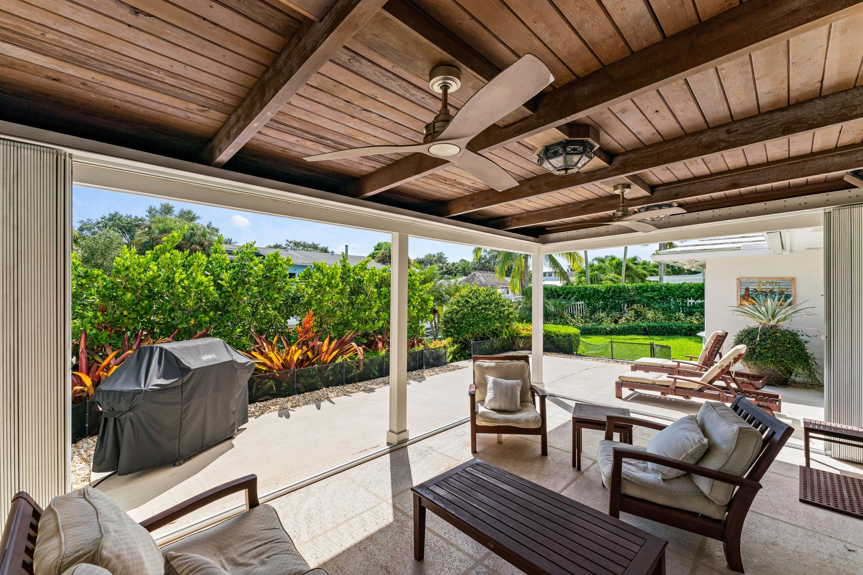 18150 Perigon Way Jupiter, FL 33458 - Photo 31 of 57 a living room with patio furniture and a garden