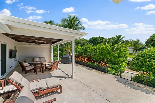 a roof deck with table and chairs and potted plants