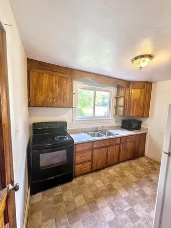 a kitchen with granite countertop a stove top oven sink and cabinets