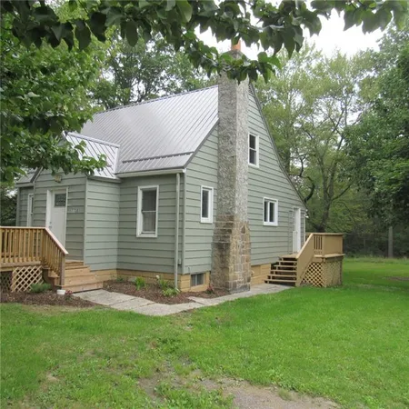 a backyard of a house with table and chairs