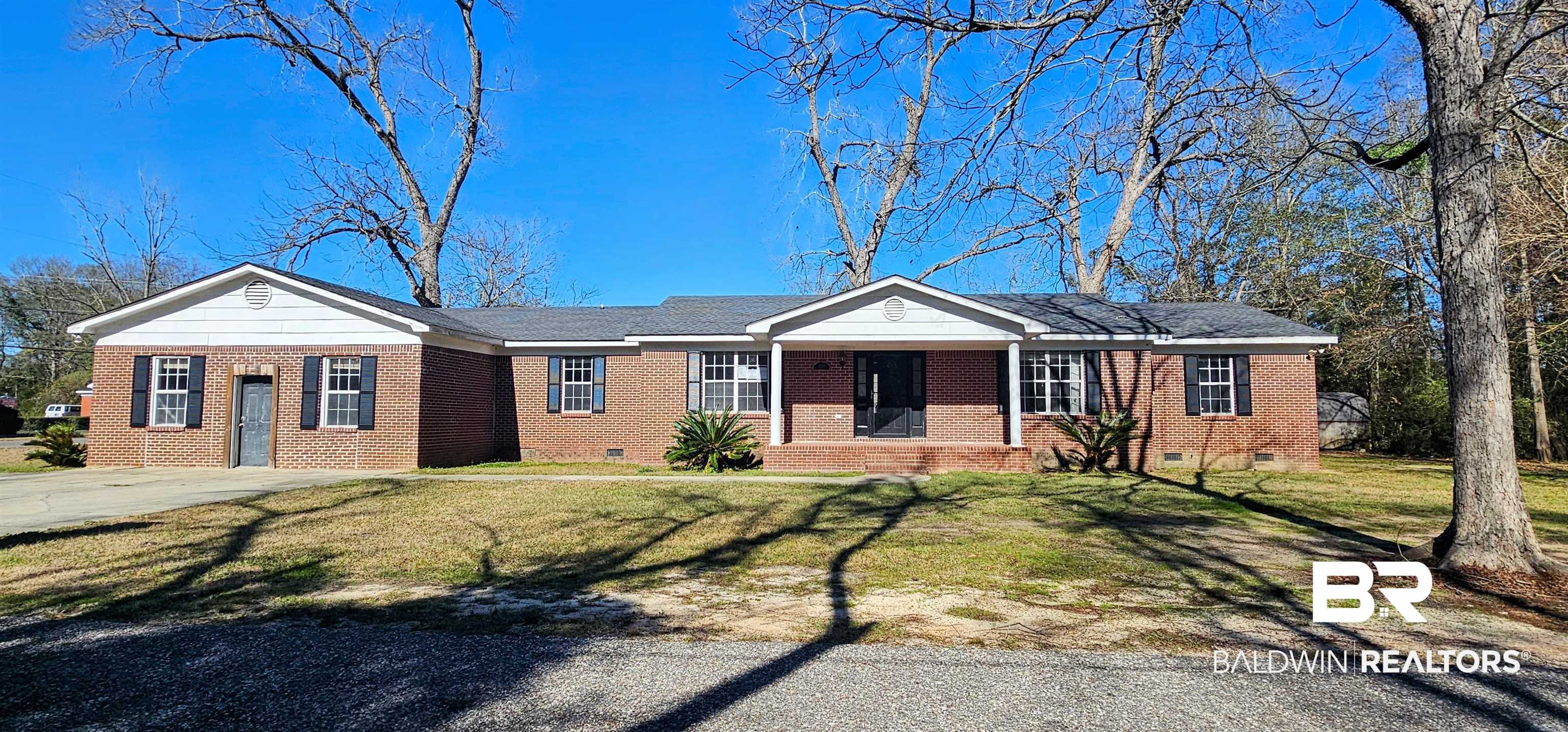 151 Bullard Street Atmore, AL 36502 - Photo 2 of 38 Ranch-style home with crawl space, a front yard, brick siding, covered porch, and driveway
