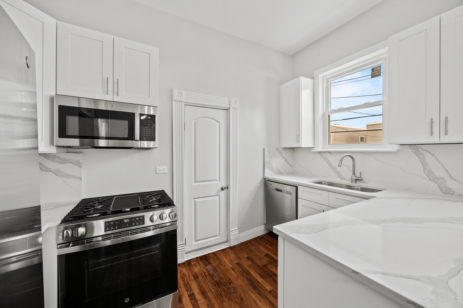 3214 West Division Street, Unit 2 Chicago, IL 60651 - Photo 2 of 14 a kitchen with stainless steel appliances a sink stove and microwave