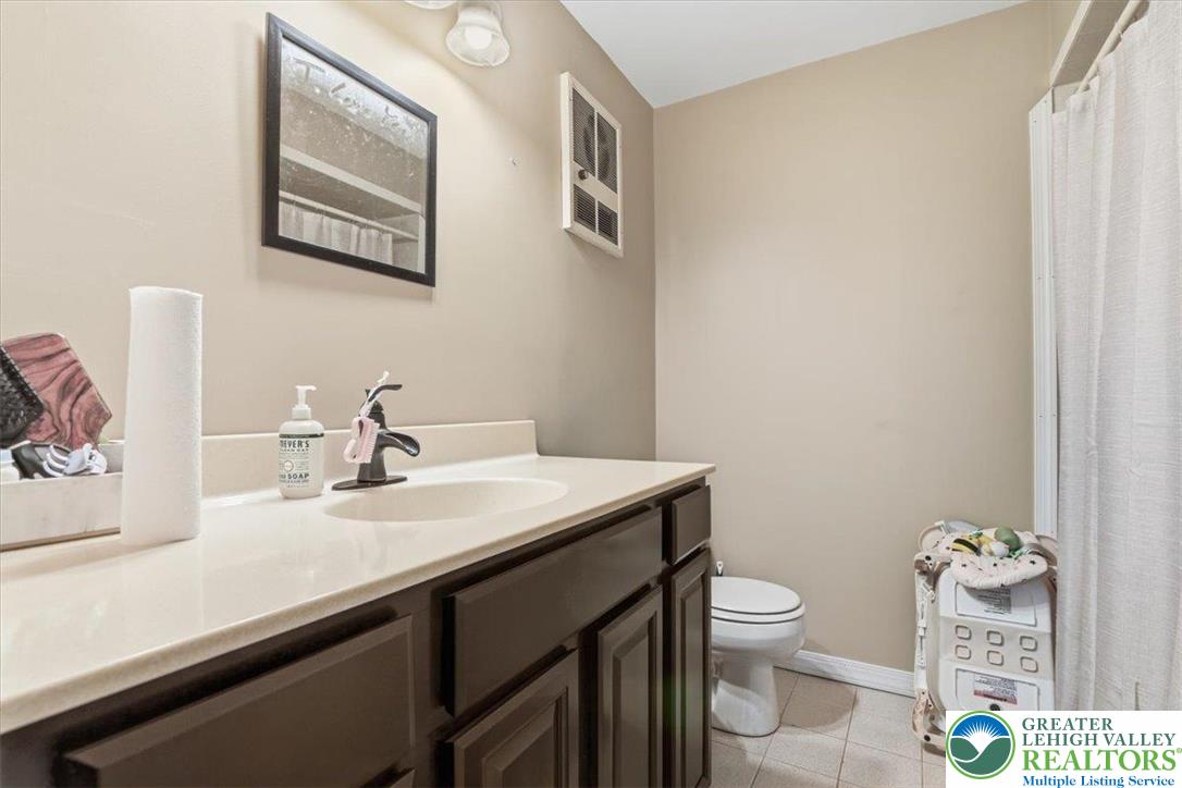 7567 Airport Road Bath, PA 18014 - Photo 48 of 67 a bathroom with a granite countertop toilet sink and mirror