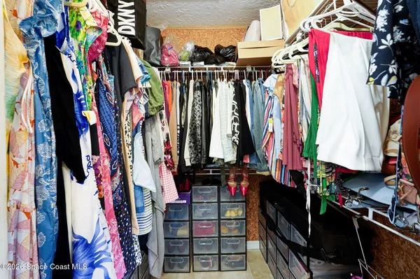 a view of walk in closet with clothes