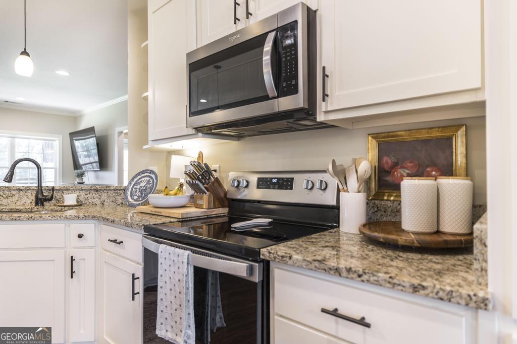 609 Live Oak Way Dublin, GA 31021 - Photo 15 of 37 a kitchen with stainless steel appliances granite countertop a sink stove and microwave