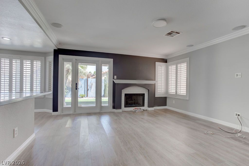1416 Walstone Road North Las Vegas, NV 89031 - Photo 18 of 47 A fireplace takes center stage in this bright living area with light hardwood floors and French doors opening to the yard.