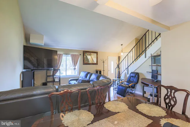 a living room with furniture a flat screen tv and a window