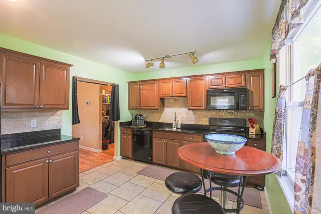 a kitchen with stainless steel appliances a dining table and chairs