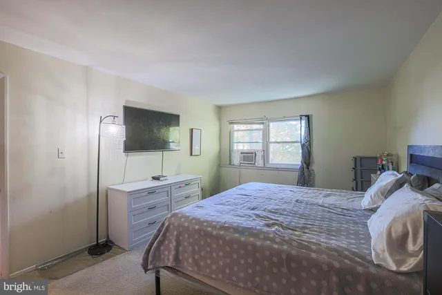 a bedroom with a bed window and dresser
