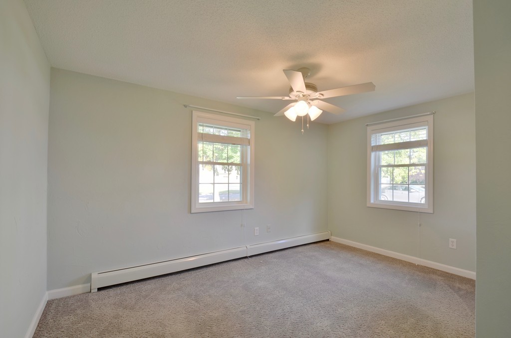 1117 Thompson Road Thompson, CT 06277 - Photo 17 of 20 an empty room with windows and chandelier fan