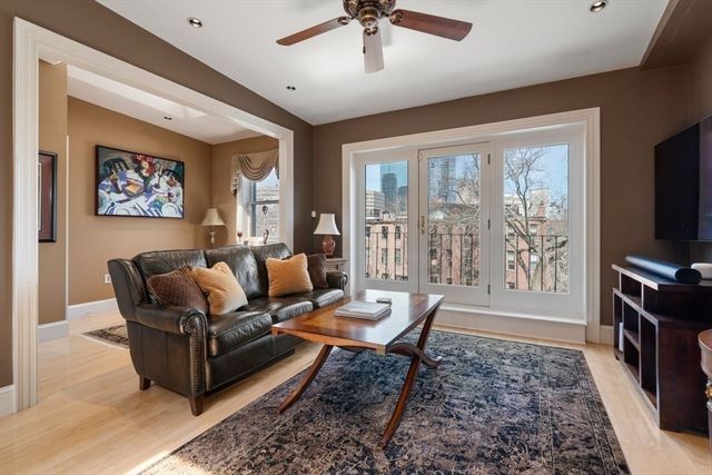 a living room with furniture a flat screen tv and a large window