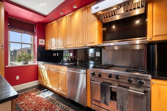 a kitchen with stainless steel appliances granite countertop a stove a sink and a microwave