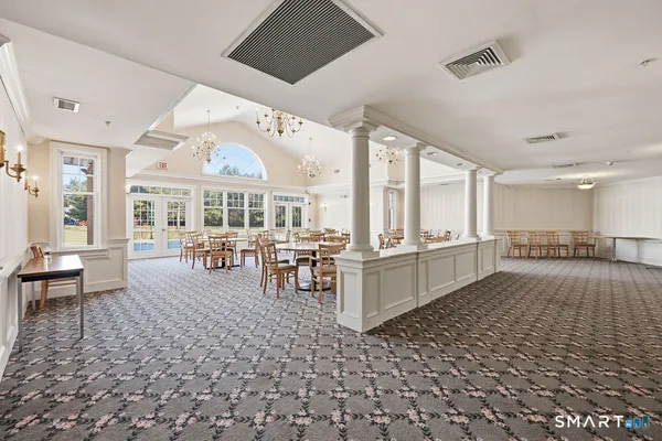 a large room with lots of tables a large window and chairs