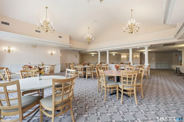 a dining room with wooden floor a chandelier a wooden table and chairs