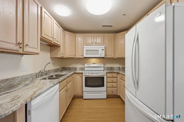 a kitchen with stainless steel appliances granite countertop a stove and a refrigerator