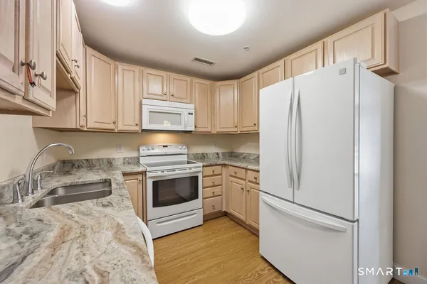 a kitchen with stainless steel appliances granite countertop a refrigerator sink and stove
