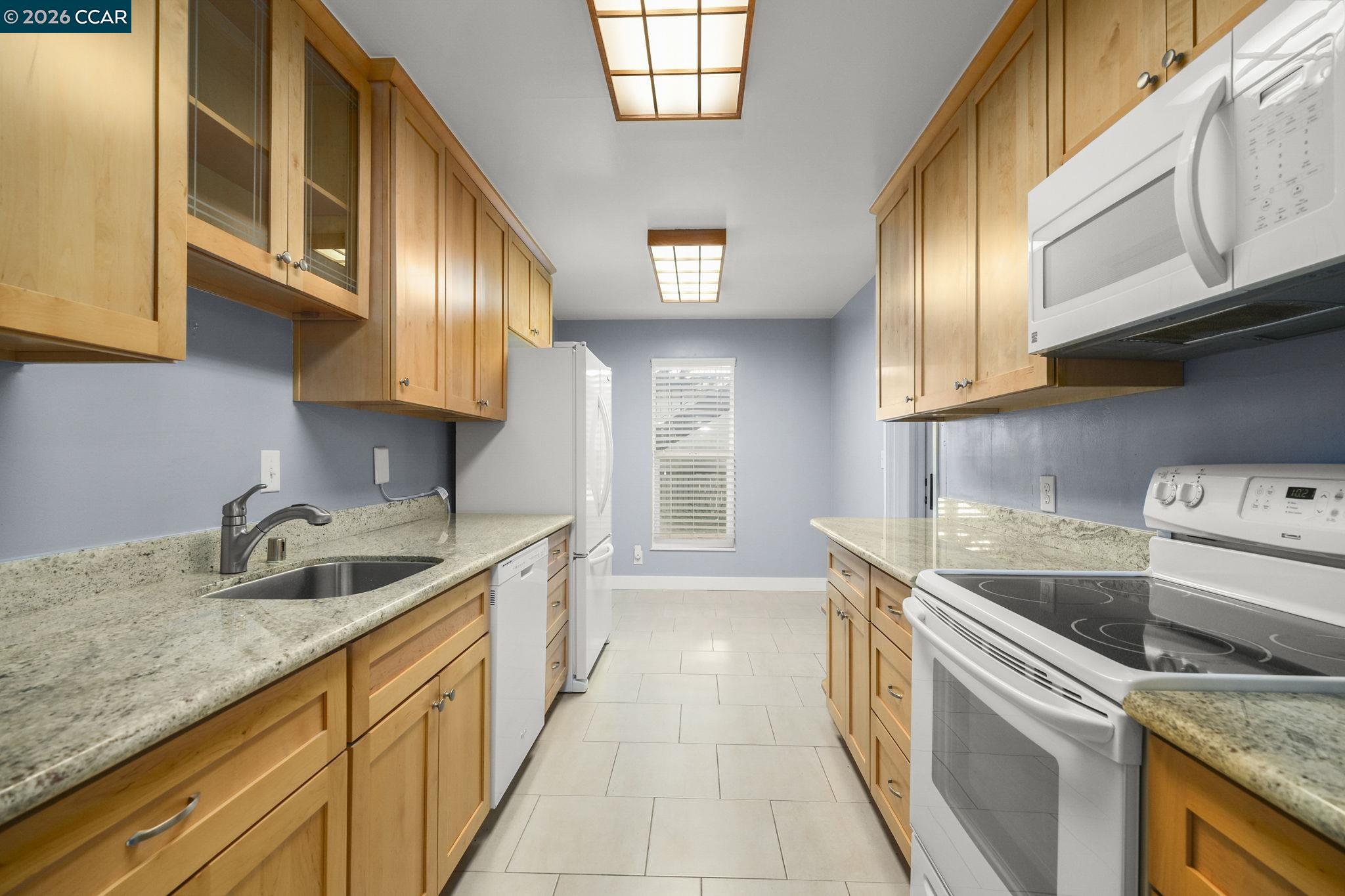 651 Moraga Road, Unit 13 Moraga, CA 94556 - Photo 10 of 27 a kitchen with granite countertop a sink a stove and cabinets