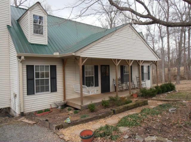 1568 Camp Ravine Road Burns, TN 37029 - Photo 4 of 20 a front view of a house with garden