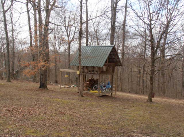 1568 Camp Ravine Road Burns, TN 37029 - Photo 8 of 20 a view of backyard with table and chairs and a large tree