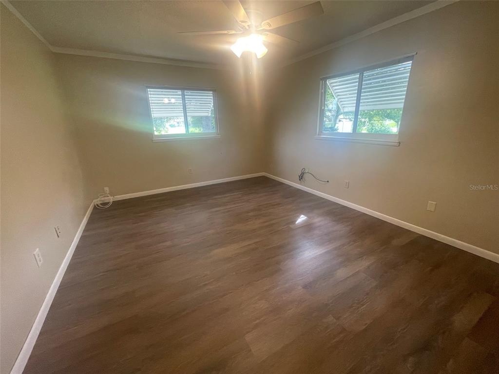 10028 Southwest 88th Terrace Ocala, FL 34481 - Photo 15 of 22 an empty room with wooden floor and windows